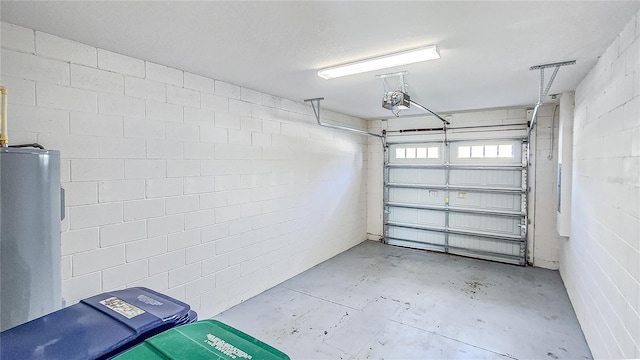 garage featuring concrete block wall, electric water heater, and a garage door opener