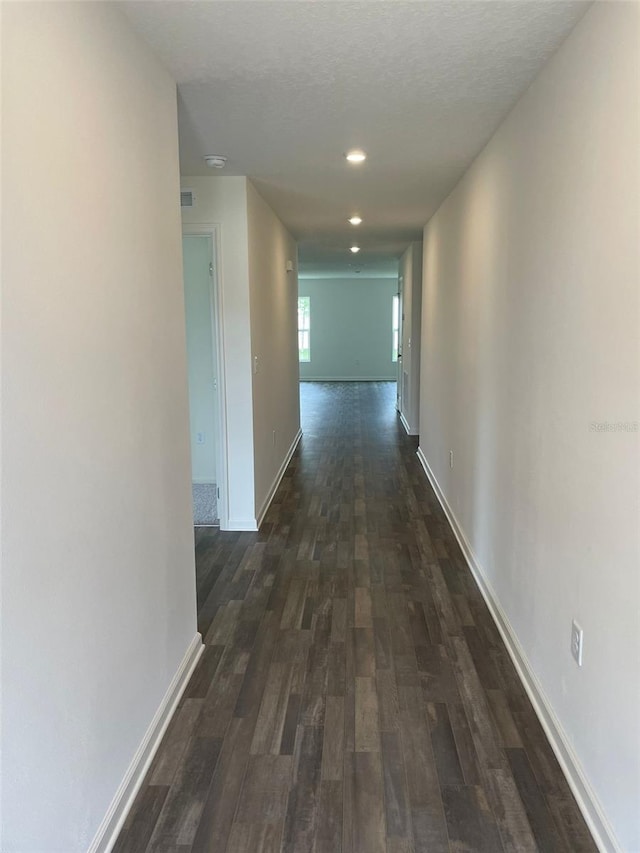 corridor featuring dark hardwood / wood-style floors and a textured ceiling