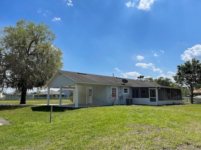 back of property featuring central AC and a yard