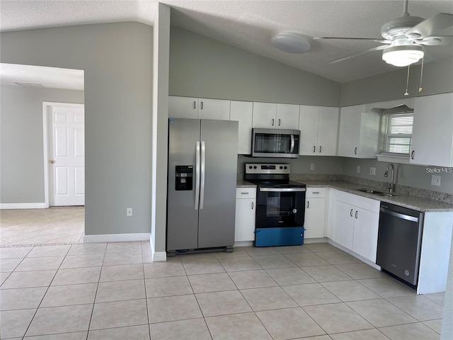 kitchen featuring white cabinets, a textured ceiling, stainless steel appliances, and lofted ceiling