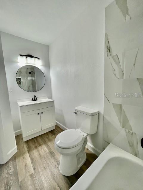 bathroom featuring wood-type flooring, vanity, and toilet