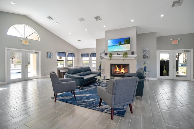 living room featuring french doors, light hardwood / wood-style flooring, and high vaulted ceiling