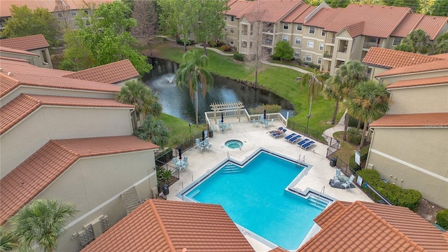 view of pool featuring a patio and a water view