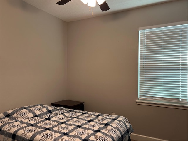 bedroom with ceiling fan and a textured ceiling