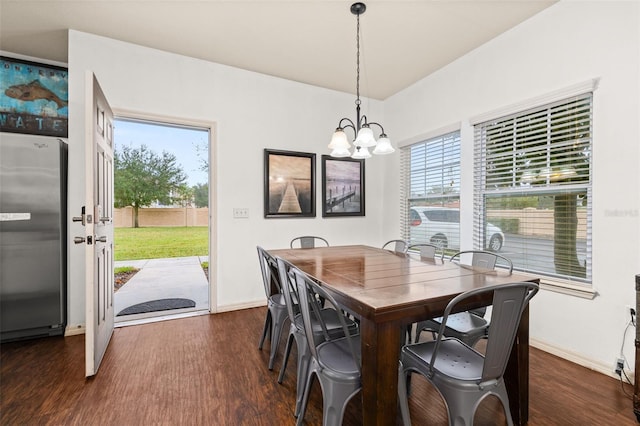 dining space featuring dark hardwood / wood-style flooring and an inviting chandelier