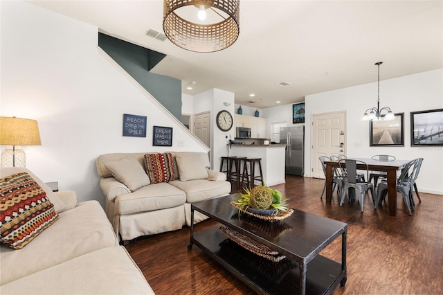 living room featuring dark wood-type flooring and a chandelier