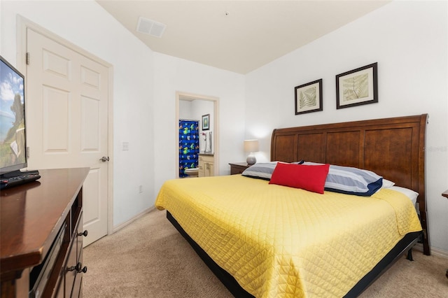 bedroom featuring light carpet and connected bathroom