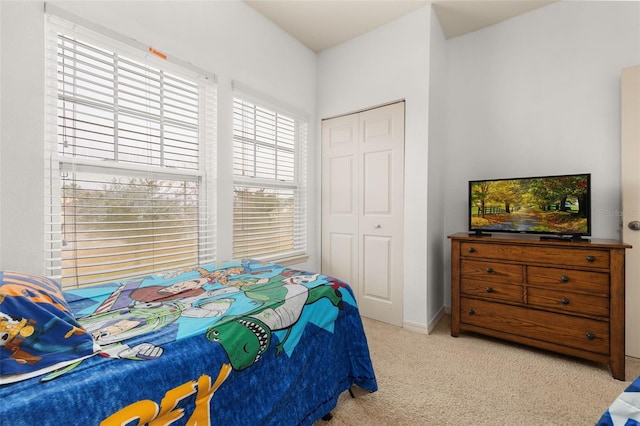 bedroom featuring light carpet and a closet