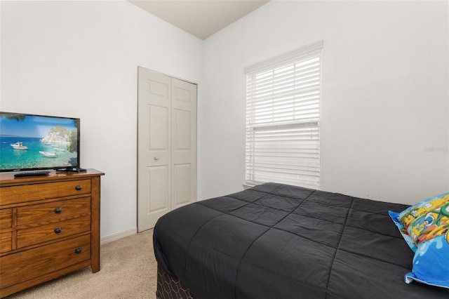 bedroom featuring light colored carpet and a closet