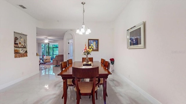 dining space with ceiling fan with notable chandelier