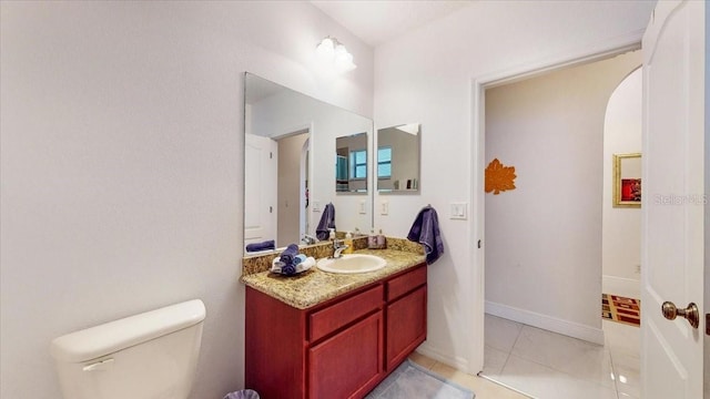 bathroom with tile patterned flooring, vanity, and toilet