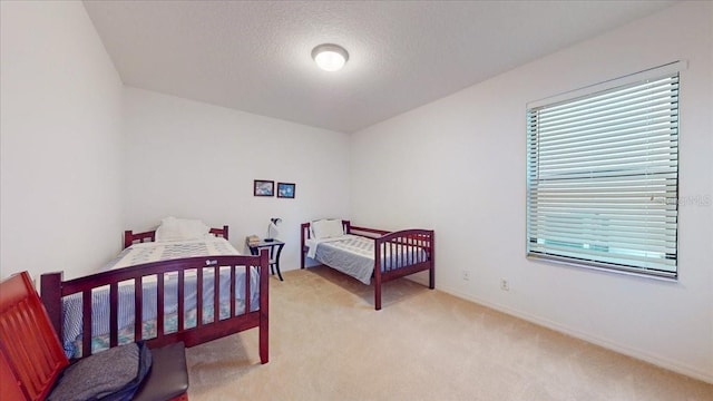 bedroom with light carpet and a textured ceiling