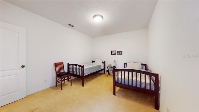 bedroom with light carpet and a textured ceiling