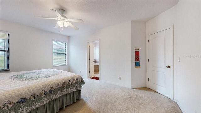 carpeted bedroom with connected bathroom, ceiling fan, and a textured ceiling