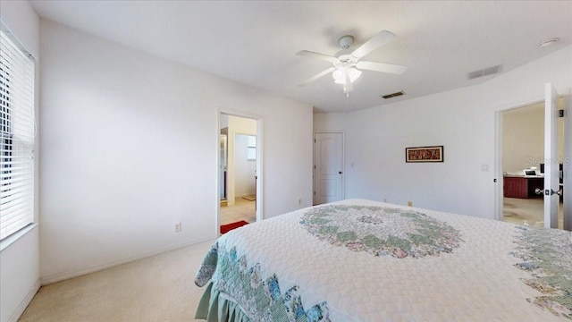 carpeted bedroom featuring ceiling fan and ensuite bathroom