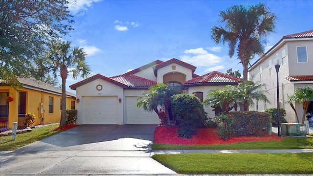 mediterranean / spanish-style house featuring central AC unit and a garage