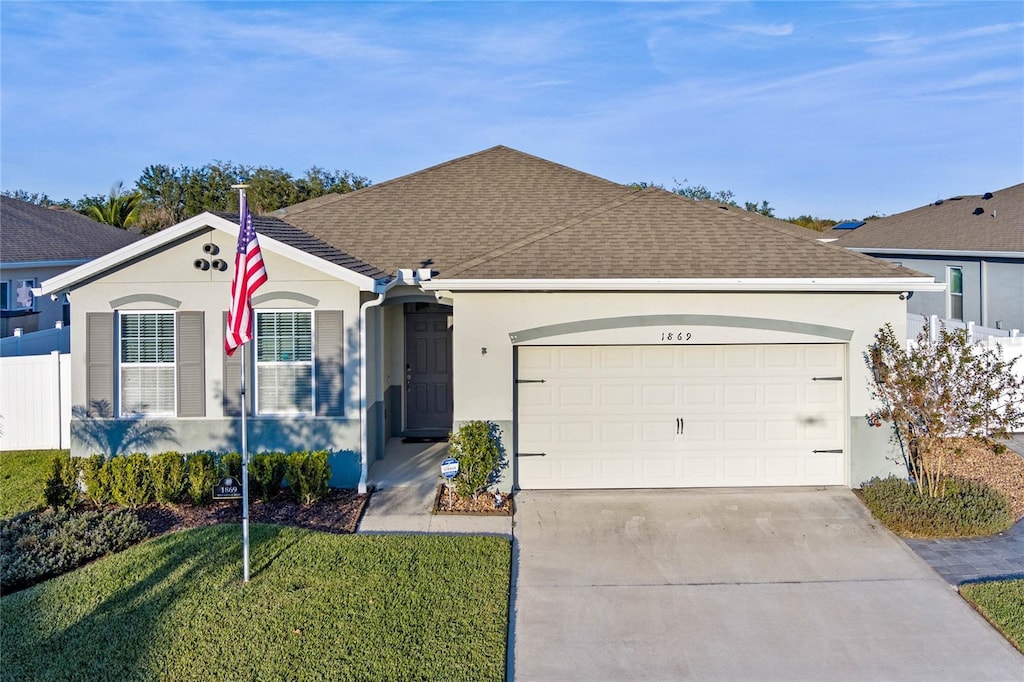 ranch-style house featuring a front lawn and a garage