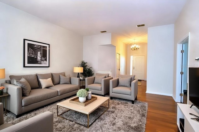 living room with dark hardwood / wood-style flooring and a notable chandelier