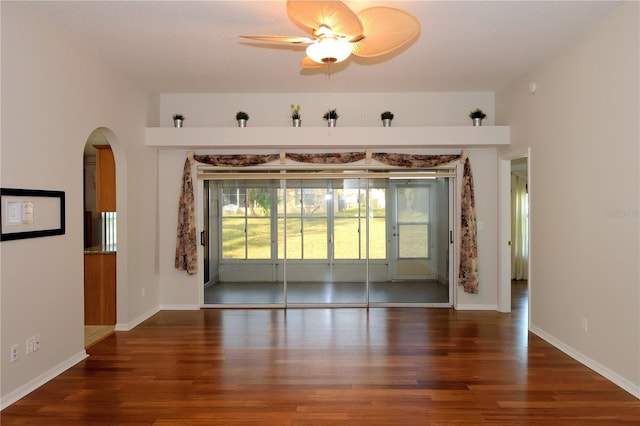 empty room with dark wood-type flooring and ceiling fan