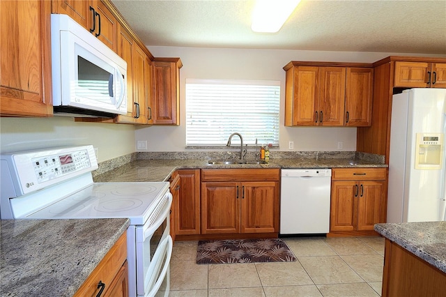 kitchen featuring light tile patterned flooring, sink, a textured ceiling, and white appliances