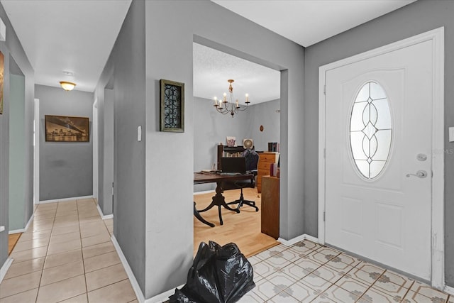 entrance foyer with light tile patterned floors and an inviting chandelier