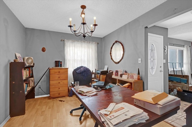 office featuring a chandelier, a textured ceiling, light hardwood / wood-style flooring, and a wealth of natural light