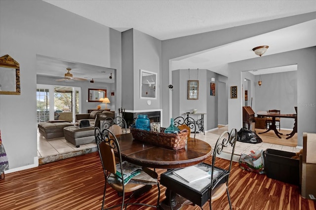 dining space with ceiling fan, wood-type flooring, a textured ceiling, and lofted ceiling