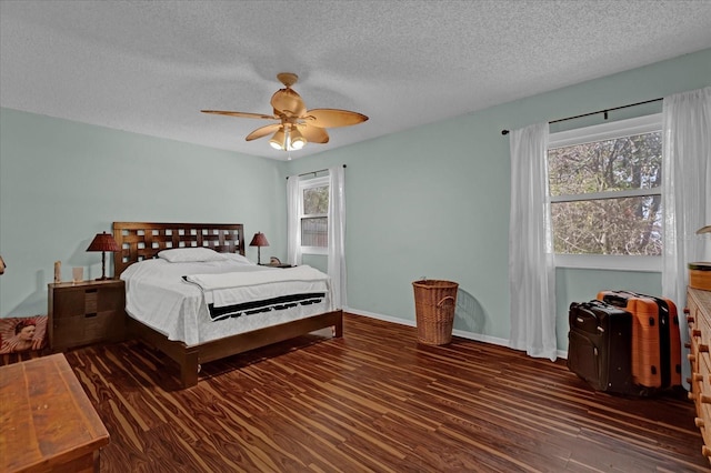 bedroom with a textured ceiling, ceiling fan, and dark wood-type flooring