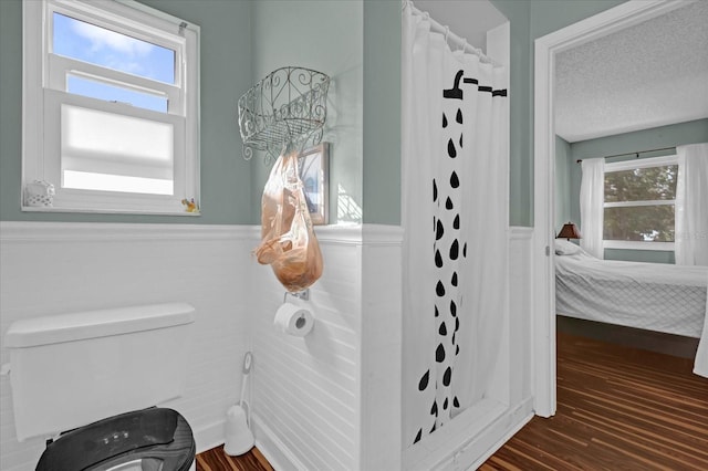 bathroom with a shower with shower curtain, hardwood / wood-style flooring, and a healthy amount of sunlight