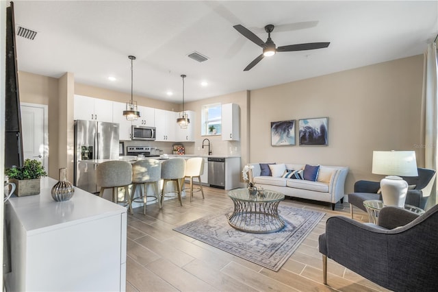 living room featuring light hardwood / wood-style flooring and ceiling fan