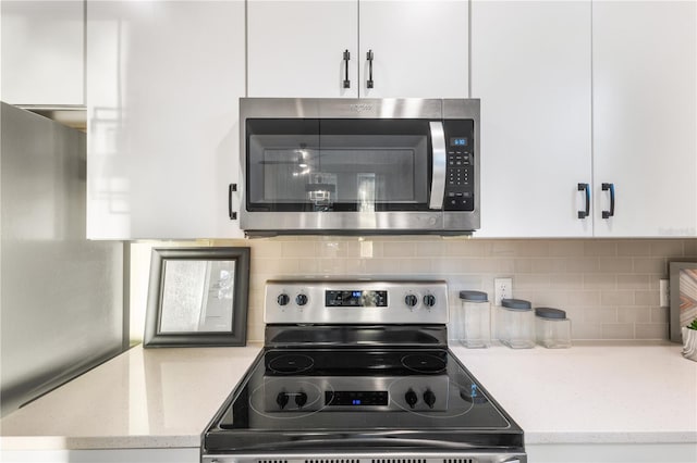 1800 Houston St, Kissimmee, FL 34743 - kitchen featuring stainless steel appliances, white cabinets, backsplash, and light stone countertops