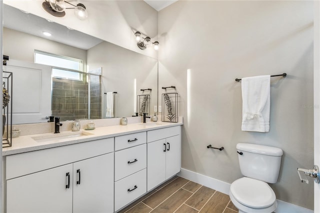 bathroom with hardwood / wood-style floors, vanity, toilet, and a shower with door