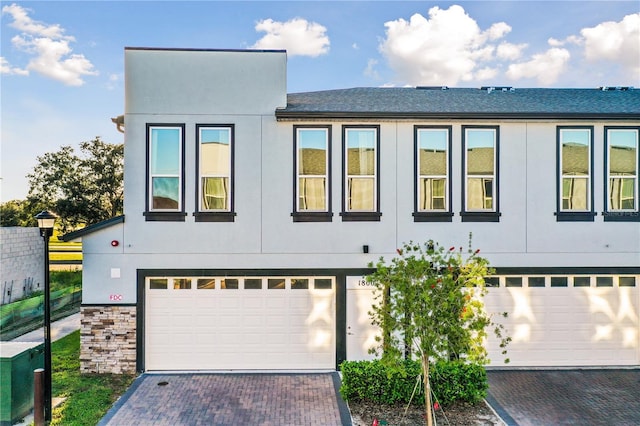 1800 Houston St, Kissimmee, FL 34743 - view of front of house featuring an attached garage, decorative driveway, and stucco siding