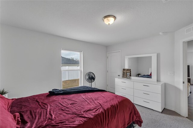 carpeted bedroom featuring a textured ceiling