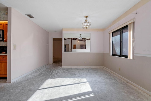 empty room with ceiling fan with notable chandelier