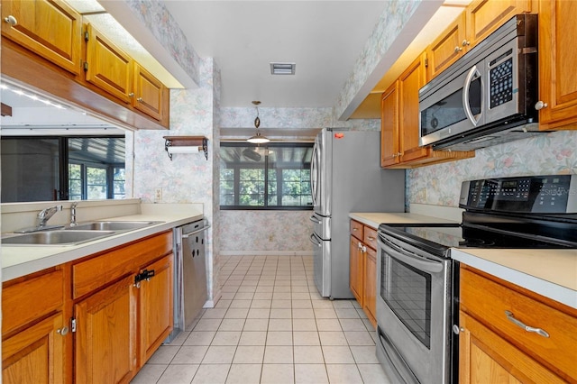 kitchen with light tile patterned flooring, sink, and appliances with stainless steel finishes