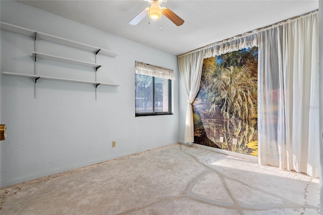 unfurnished room with ceiling fan and a textured ceiling