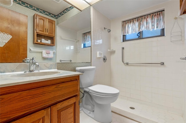 bathroom featuring plenty of natural light, toilet, a tile shower, and vanity