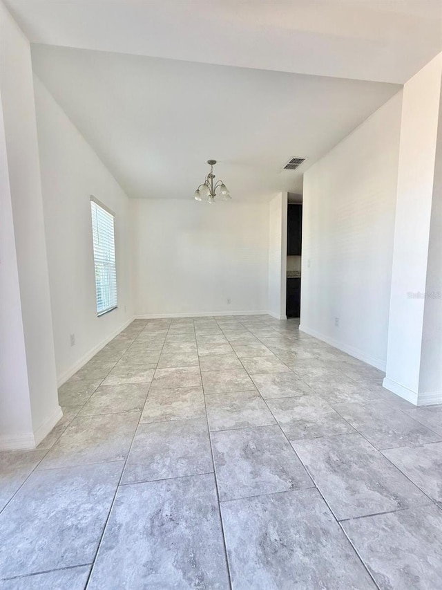 spare room featuring a chandelier