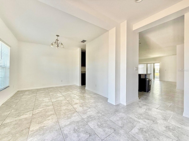 unfurnished room with a chandelier