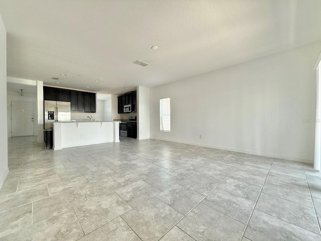 unfurnished living room featuring sink