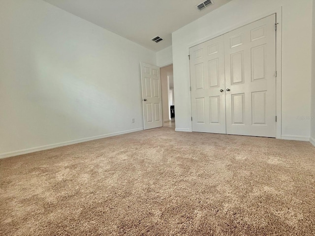 unfurnished bedroom featuring carpet and a closet