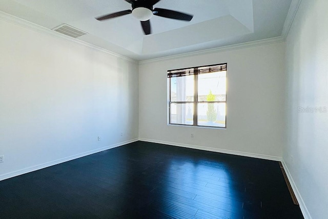 unfurnished room with dark wood finished floors, visible vents, a raised ceiling, and a ceiling fan