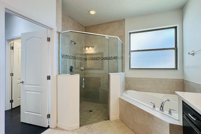 full bath with tile patterned floors, vanity, a bath, and a shower stall