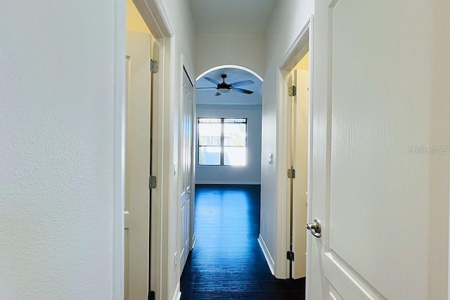 corridor with dark wood-type flooring and baseboards