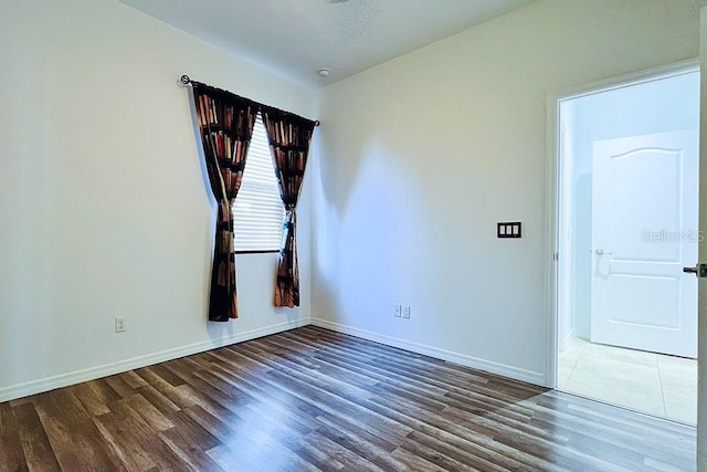 empty room featuring wood finished floors and baseboards