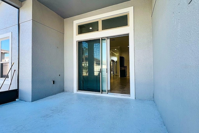 property entrance with stucco siding