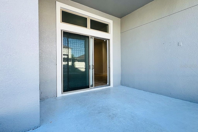 view of exterior entry featuring stucco siding