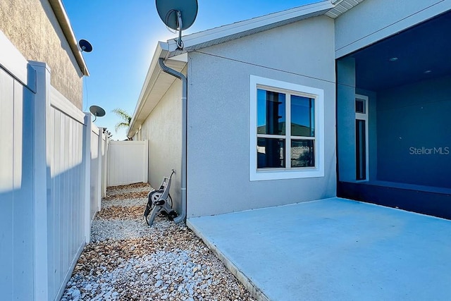 view of home's exterior featuring stucco siding and fence