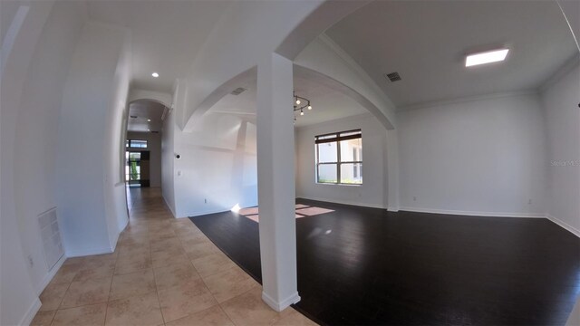 spare room featuring visible vents, crown molding, and baseboards